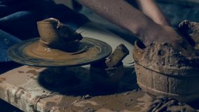 Potter's hands shaping clay bowl