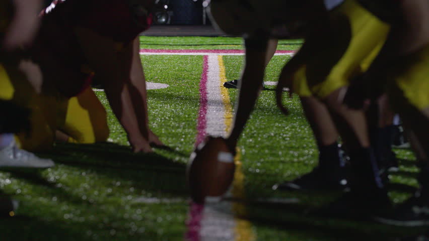 Close up of a football, as players get set at the line of scrimmage Royalty-Free Stock Footage #28066576
