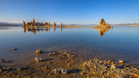 calcareous tufa formation reflects on the smooth waters of Mono Lake, one of oldest lakes in North America. Mono Lake Tufa State Natural Reserve, California, United States. Sunset time lapse.