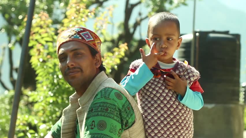 Father and son in traditional native dress look at camera, in the HImalayas in Northern India