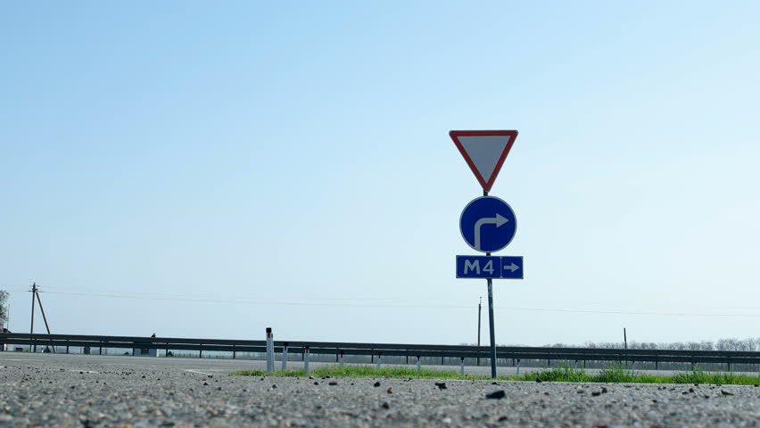 Road sign - entrance to the toll highway M4 Don. Trucks and cars pass by a road sign.