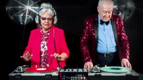 amazing DJ grandma and grandpa, older couple djing and partying in a disco setting. these retired rockers will get the party going