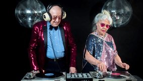 amazing DJ grandma and grandpa, older couple djing and partying in a disco setting. these retired rockers will get the party going