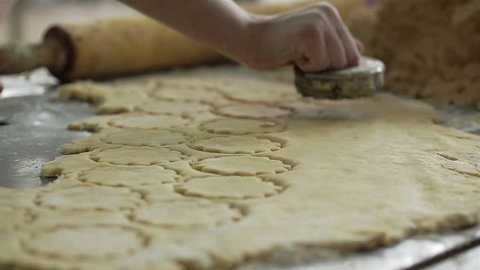 Female hands cut the cookies from the dough