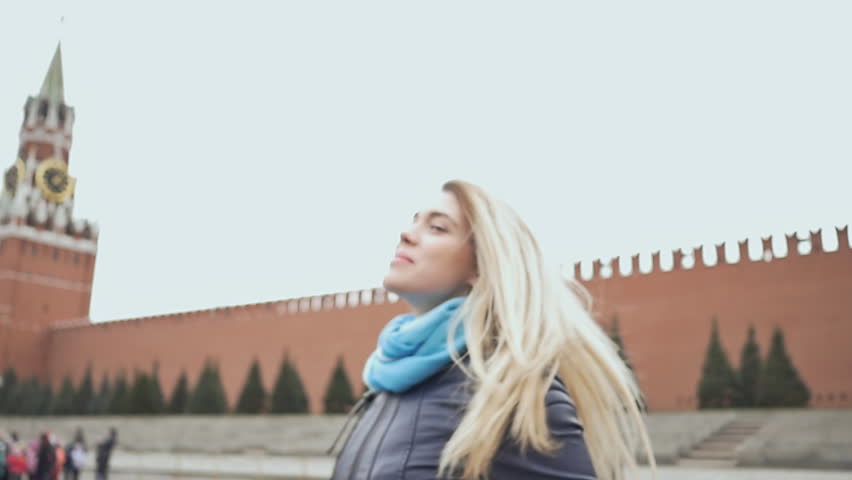 Beautiful blond girl posing against a red square in Moscow. Russia.