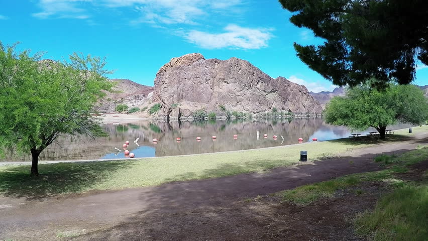 PARKER AZ/USA: May 10, 2017- Wide shot of a swim area at Buckskin Mountain State Park in Parker Arizona. A peaceful park and picnic area is seen at the edge of a marked zone for river swimming.