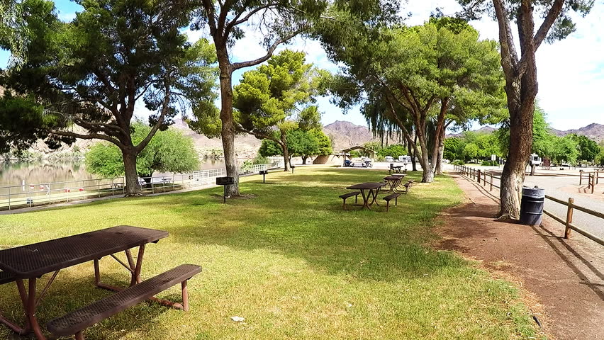PARKER AZ/USA: May 10, 2017- Shot of a picnic area by a river at Buckskin Mountain State Park. A designated gathering and eating area is set up under tall shade trees next to river attraction. 
