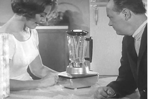 1950s: A television commercial for the Hamilton Beach Cookbook Blender features a happy housewife blending and serving her husband dessert, in 1955.