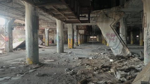CLOSE UP: Scary halls in decaying abandoned old Fisher Body Plant automotive factory, Detroit, United States. Spooky dilapidated garage in big haunted industrial building after the financial crisis