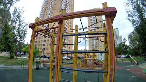 Boy rises on an iron ladder at playground in house yard
