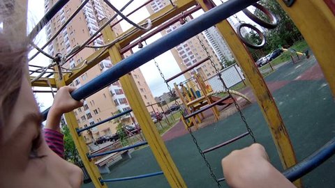Girl rises on an iron ladder at playground in house yard Stock Video