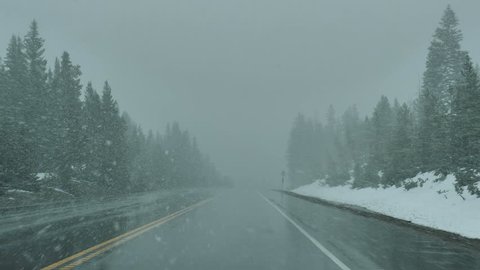 Drive Plate-POV-View forward driving through spring snow in the Colorado Rocky Mountains