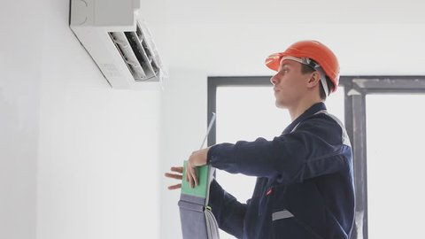 serviceman inspects and measures a air conditioning