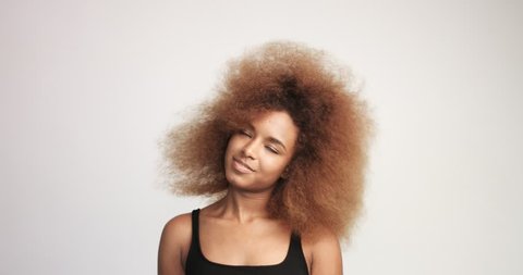 beuayt black woman with a huge afro hair having fun smiling and dancing in studio