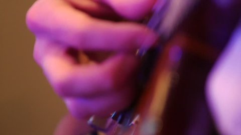 Hand of a musician on bass guitar, close-up