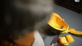 Woman cuts a pumpkin into slices close up