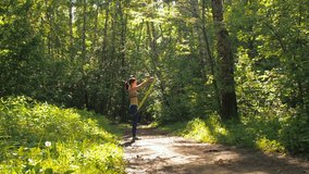 The girl is jumping rope in the park. Young girl doing sports in the forest/ The girl is jumping rope in the park. A young girl is doing sports in the forest. Slow motion video