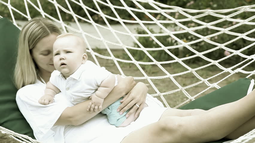 Happy baby with mother in hammock   