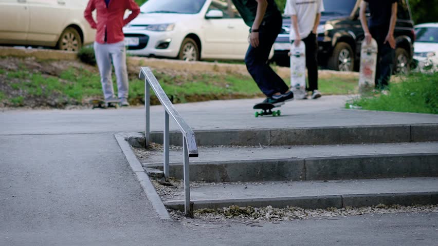 Skateboarder jumping and riding down small stairs in park