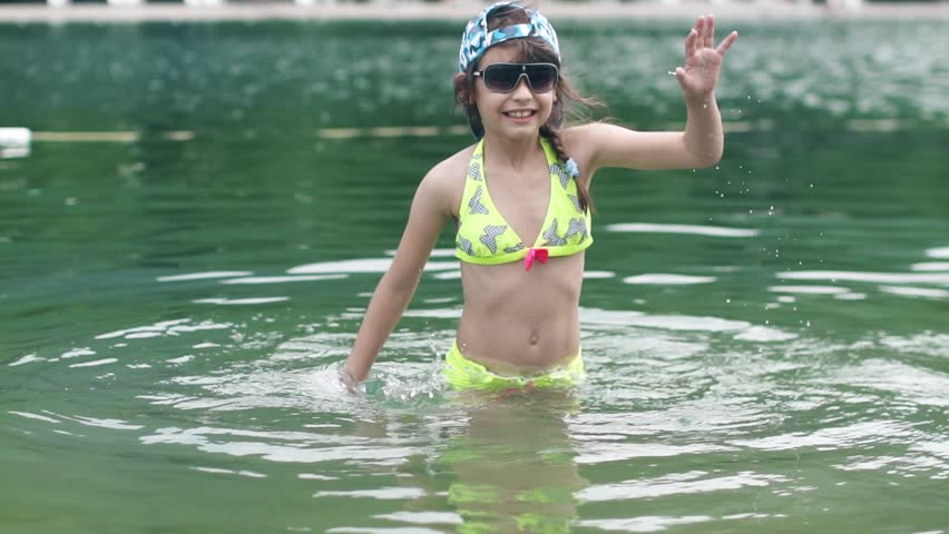 little girl playing in the water. baby having fun and splashing in river water. Slow motion