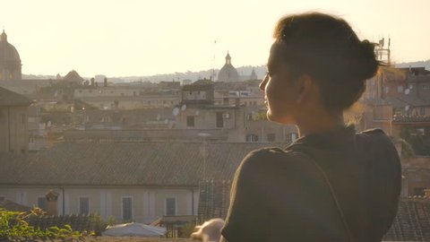 Young woman in campidoglio balcony admires rome's cityscape
