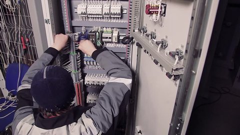 Man working with wires in electric meter.