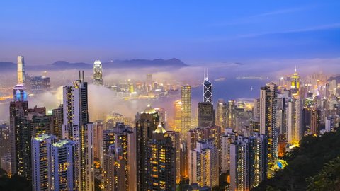 Time lapse Hong Kong skyline from famous Peak View at night. Fog rushing into the city. 