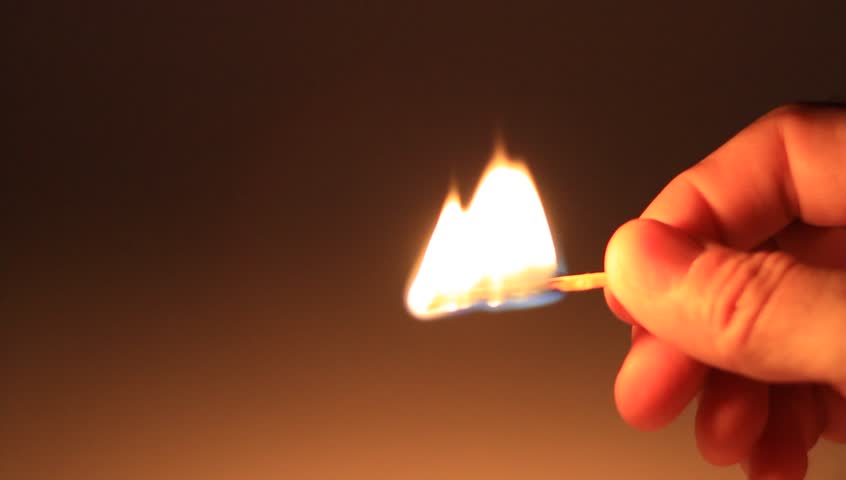 Man holds a lighted matchstick
