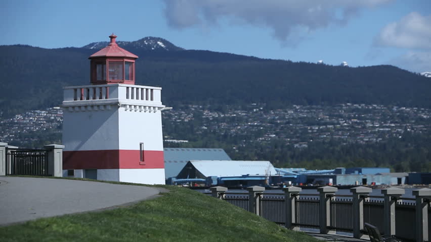 A man on a bicycle passes the Lighthouse in Stanley Park, Vancouver, Canada  