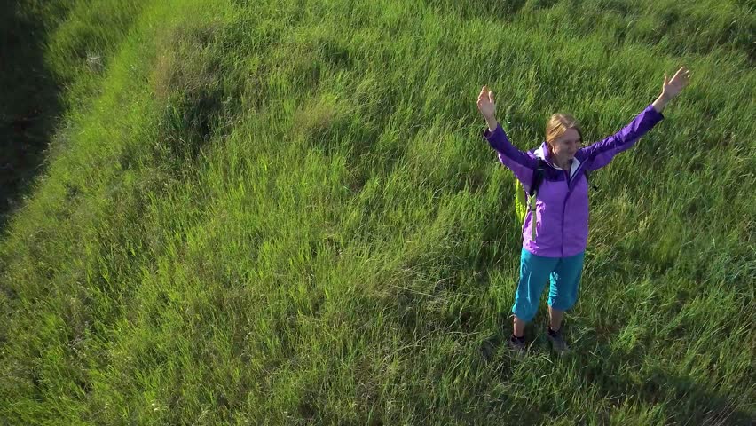 Woman enjoys hiking with a backpack over hilly terrain. Hiking. View from height