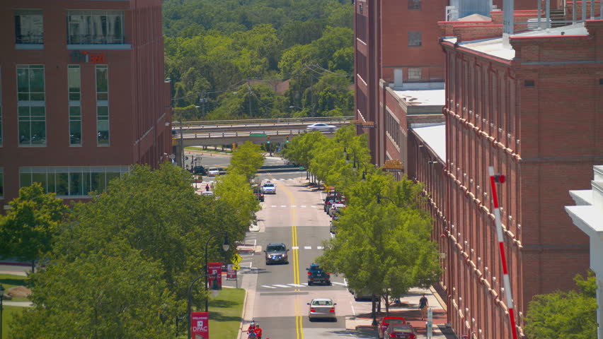 Durham NC Downtown Street Scene with Vehicles Driving Through the American Tobacco Campus on a Sunny Summers Day in North Carolina