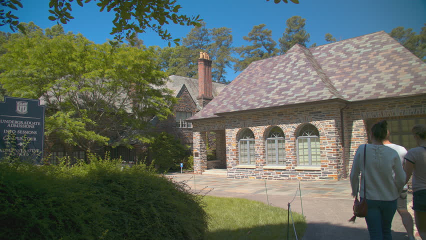 DURHAM, NC - 2017: Duke University Office of Undergraduate Admissions Building Exterior with People Walking by on a Sunny Day in North Carolina