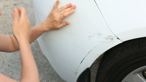 looking at a damaged vehicle. Woman blonde inspects car damage after an accident