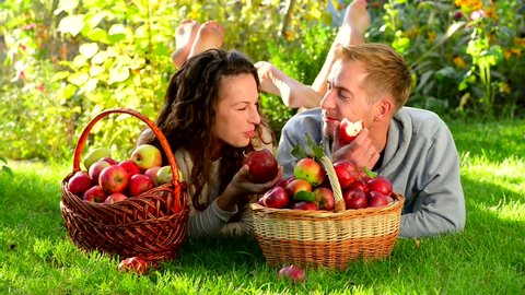 Happy Couple in Autumn Garden.Having Fun on the Grass and Eating Apples Healthy Food.Outdoor.Park. Stock Video