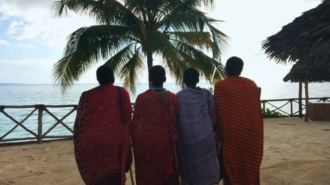 The Masai tribe dances their national African dance on the Indian Ocean beach at sunset and bids farewell to the sun. Tanzania. Zanzibar. 4K.