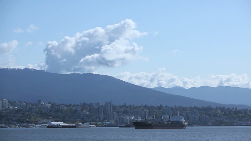 Waterplane taking off at Vancouver Harbor with cargo freighters in the