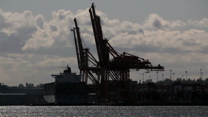 Cranes at the container port terminal in Vancouver BC with dramatic sky cloud