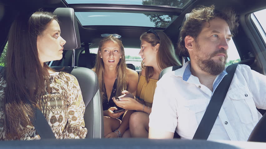 Teenage daughters laughing while parents are fighting in car unhappy
