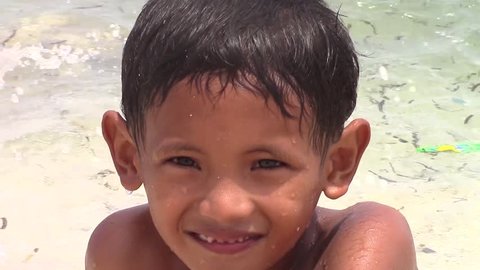 SULANGAN, PHILIPPINES - CIRCA MARCH 2017:  portrait of a Filipino kid that plays and baths on a beach on the ocean near the village of Sulangan, Eastern Samar, Philippines.