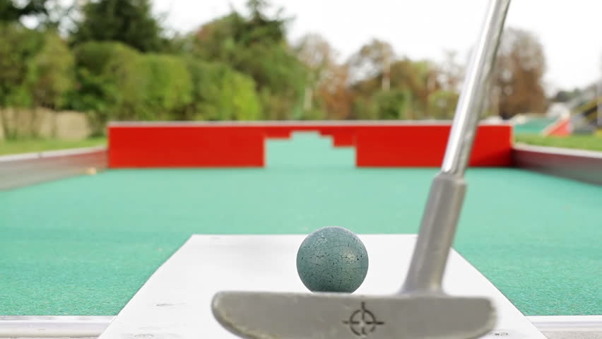 Young woman playing mini-golf during cloudy day, selective focus, successful