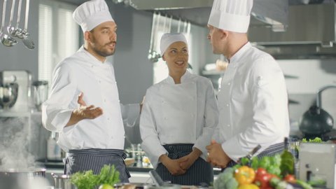 In the Modern Kitchen Team of Cooks Have Discussion. Kitchen is Full of Food Ingredients, Vegetables, Meat, Boiling Soup.  Shot on RED EPIC-W 8K Helium Cinema Camera.