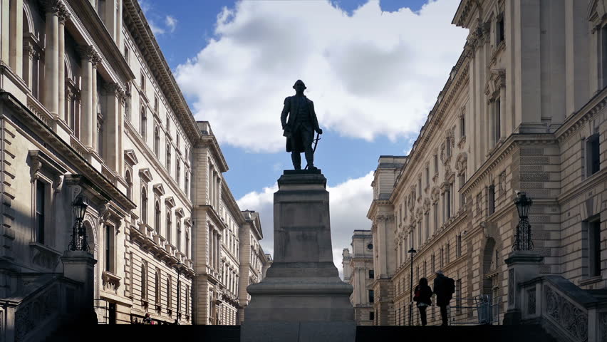 People Walk Up Steps By Classical Buildings And Statue