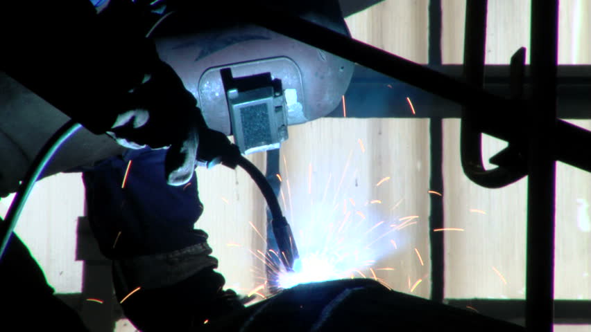 Man welding in shipyard with protective equipment