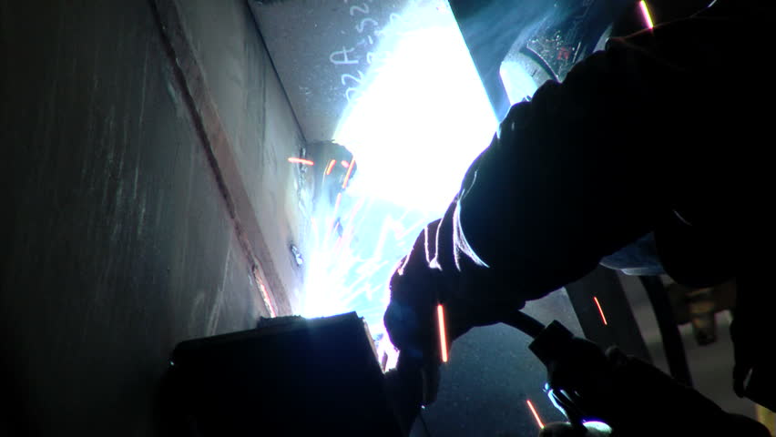 Man welding in shipyard with protective equipment