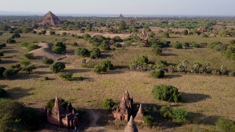 Aerial descending shot of the Bagan archeological site in Myanmar .