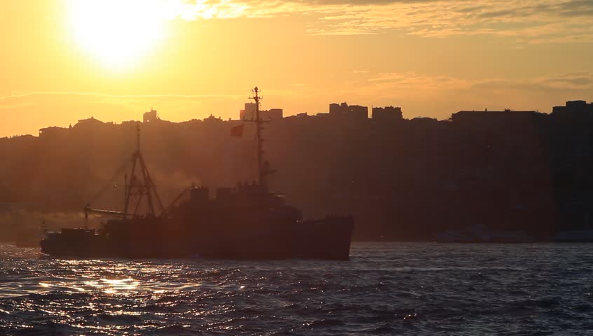 City Sunset. Ship passing in front of the city silhouette
