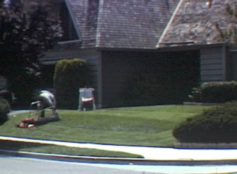 Vintage 1982 super 8 time lapse of young man mowing a suburban lawn. 