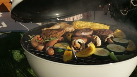 opening kettle barbecue grill in garden
