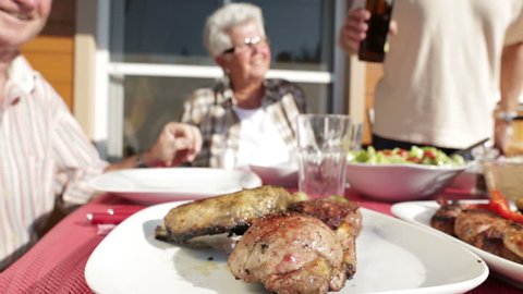 seniors at barbecue table with beer
