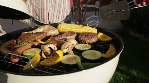 closing kettle barbecue grill in garden